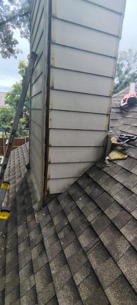 Water restoration roof repair by a chimney.