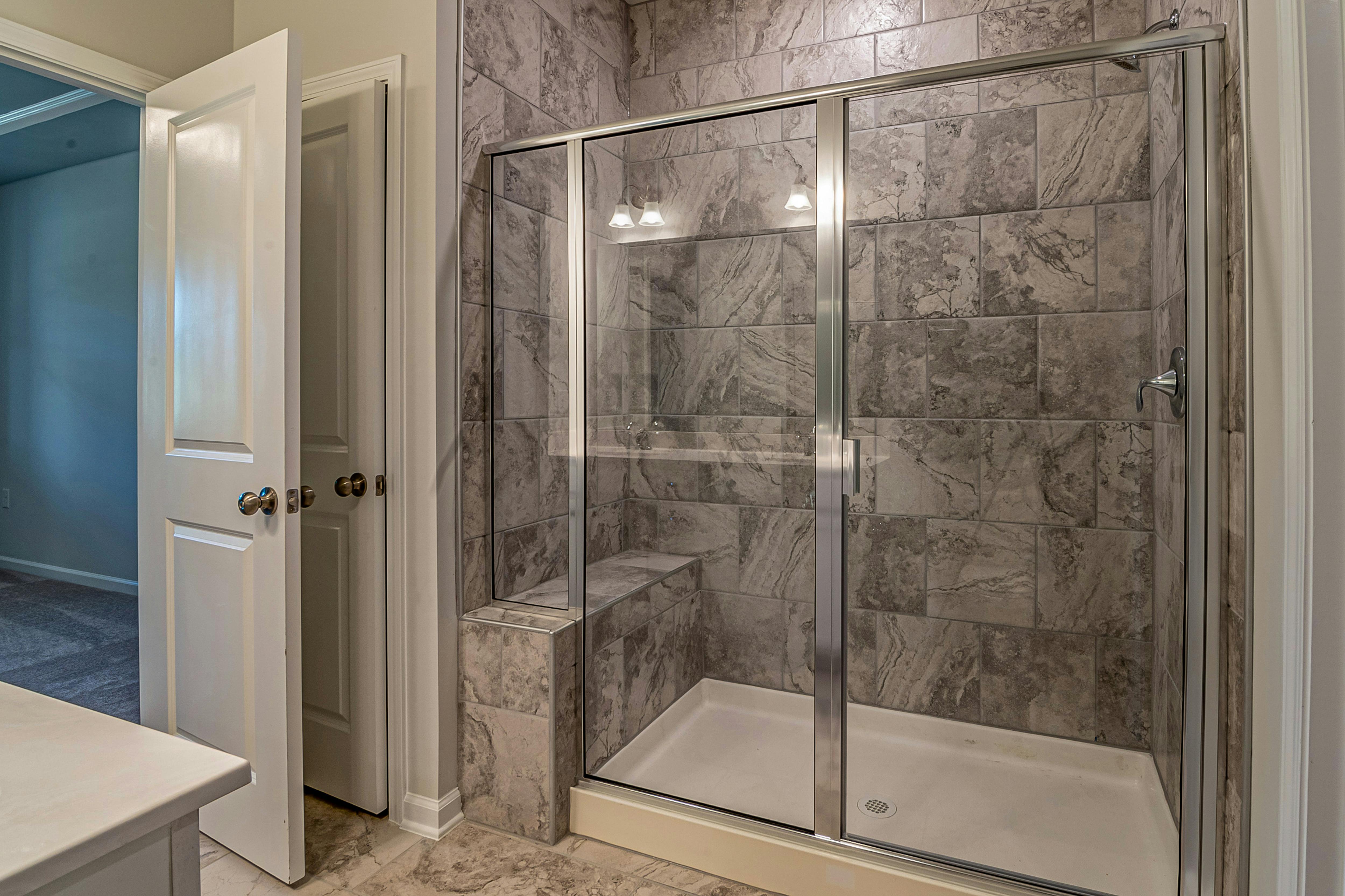Shower rempdel with glass doors and white walls.