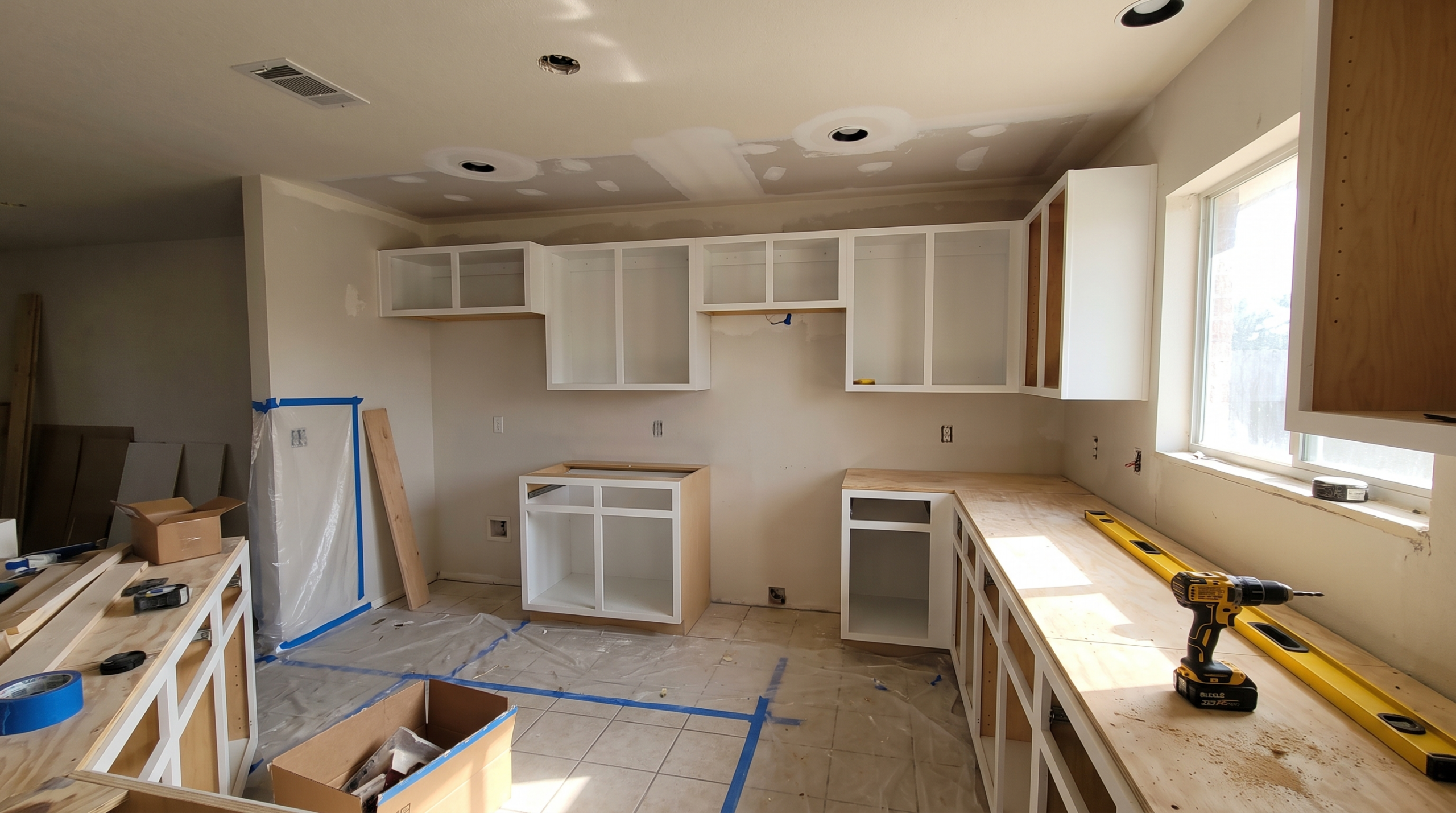 Kitchen remodel in progress in a 1990s McKinney home with new cabinet boxes installed and drywall patched